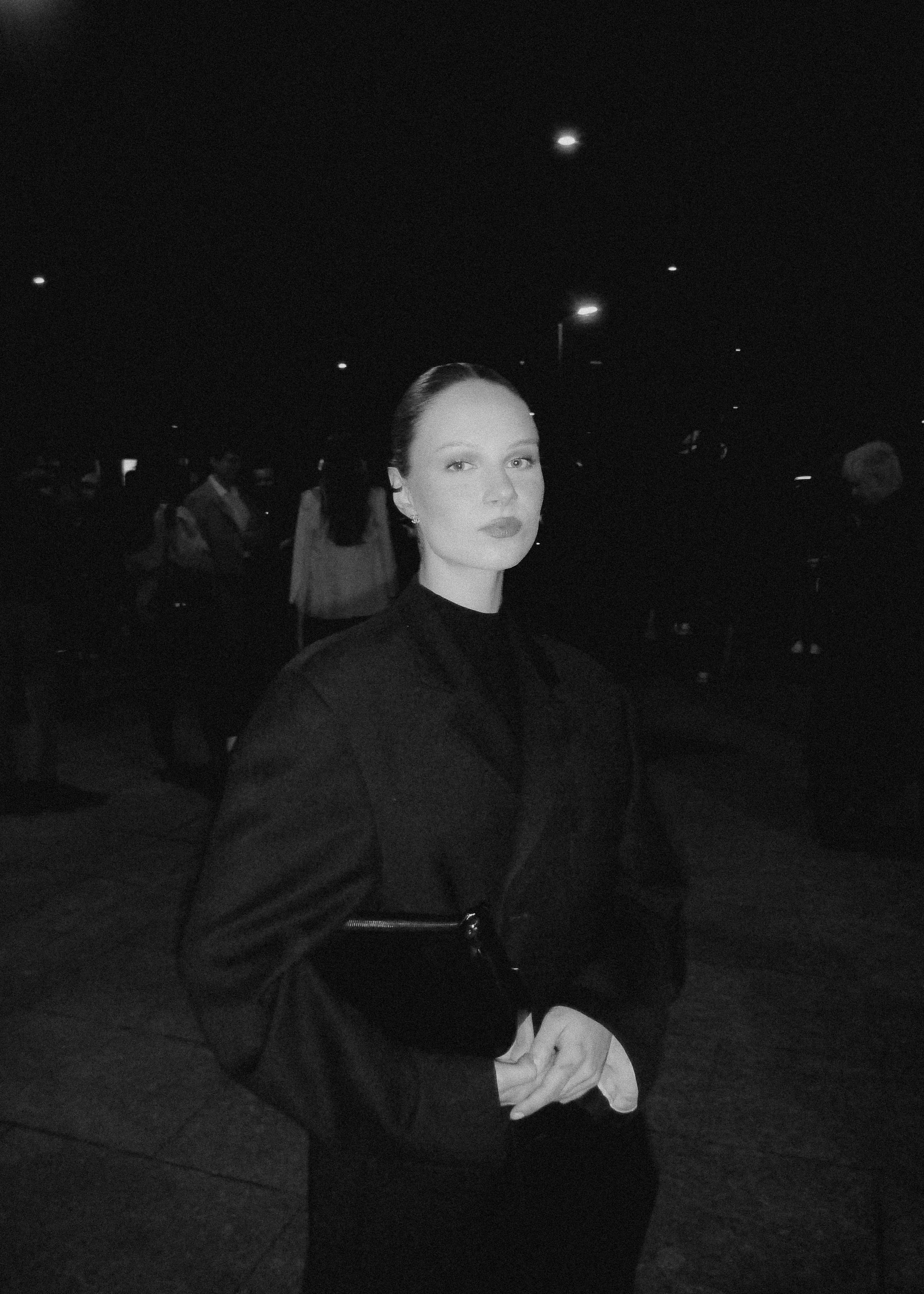 A member of the collective in a dark coat, photographed at night
