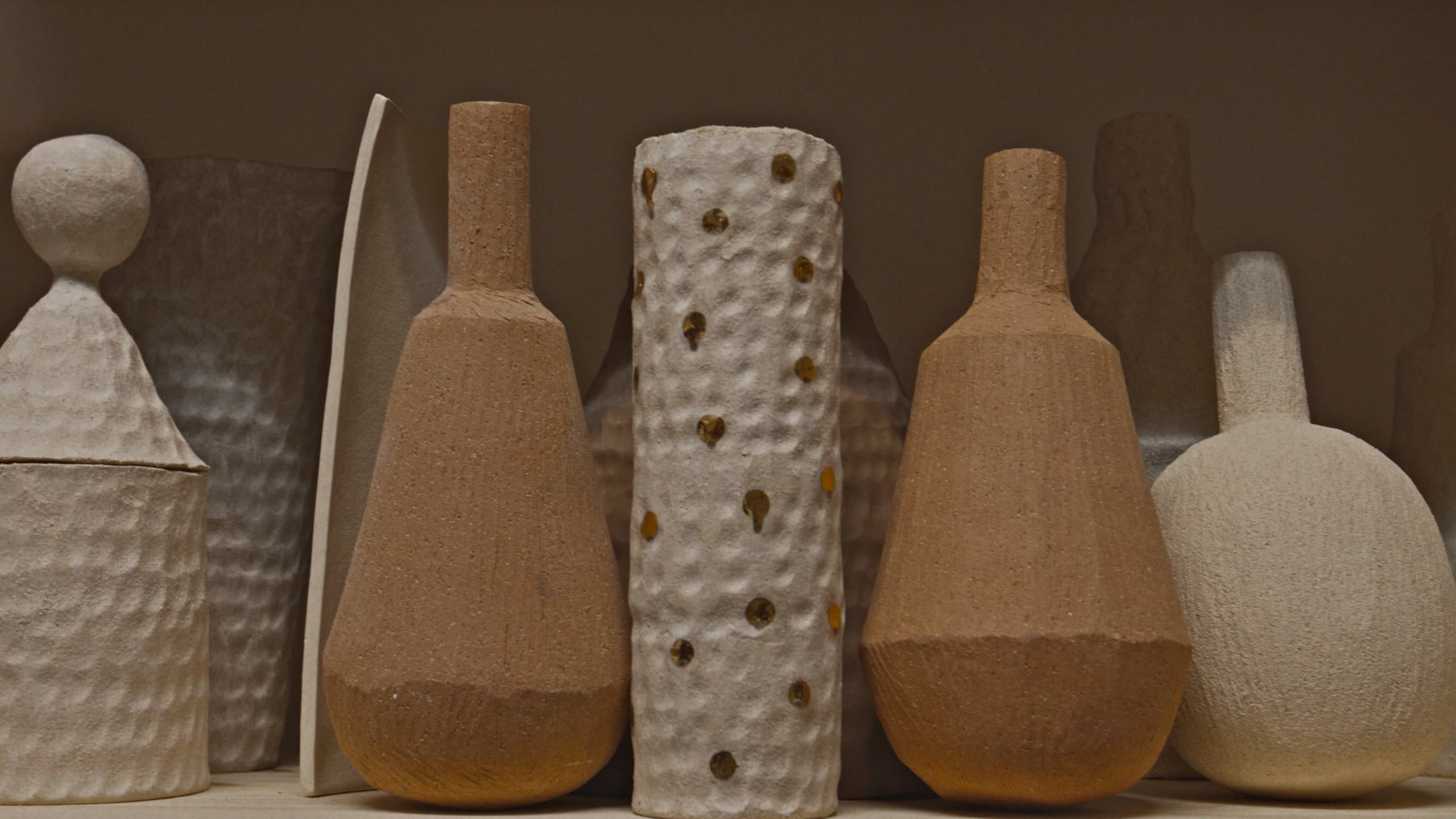 A row of textured ceramic vessels