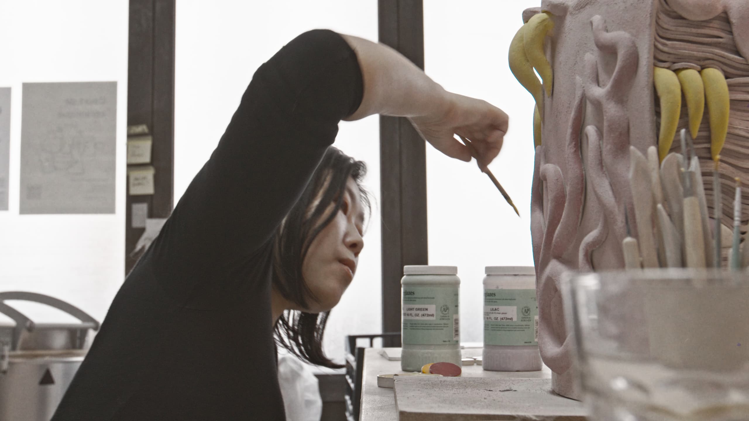 An artisan painting a large clay relief