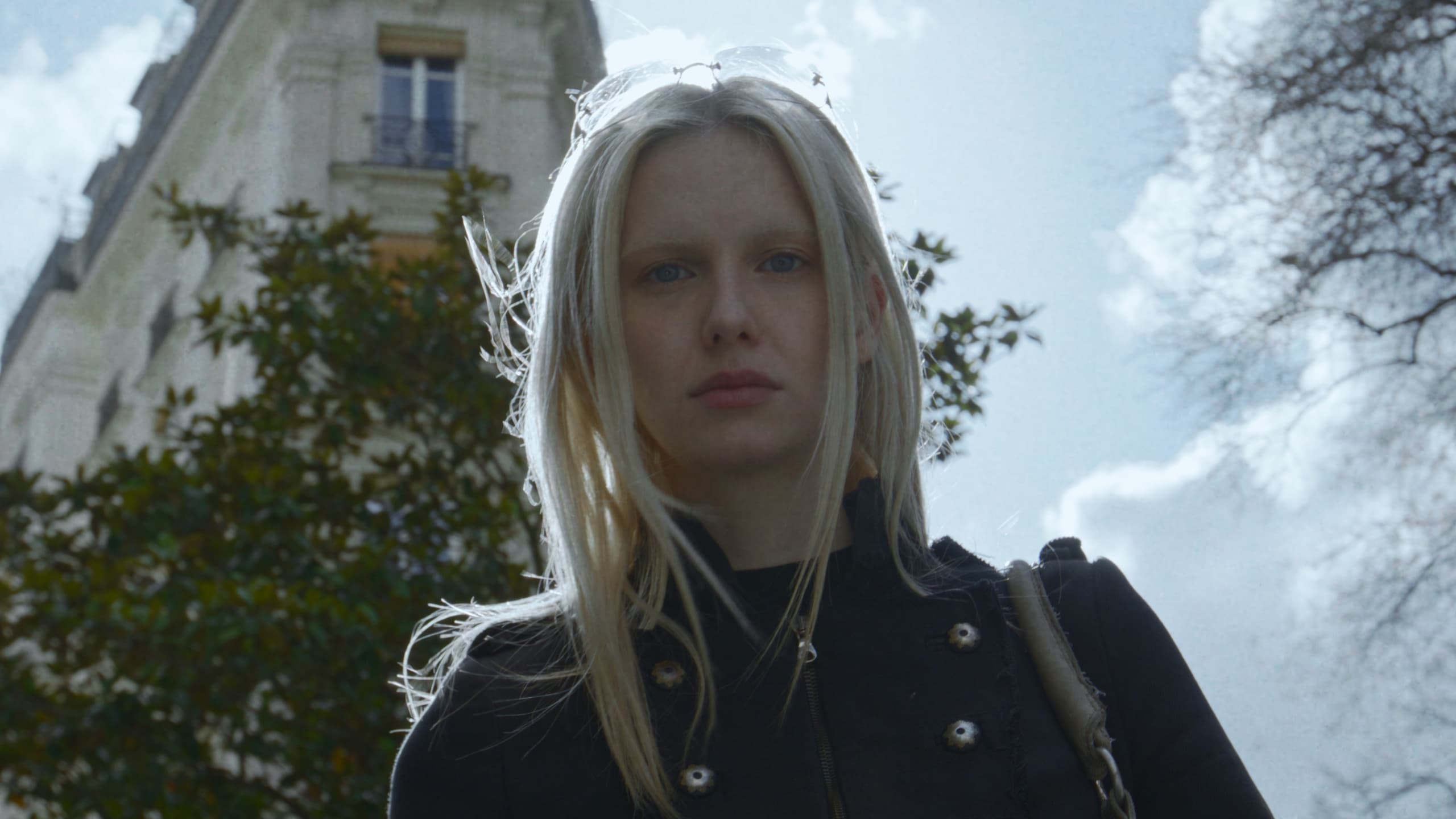 Lea Pliger seen from below against a Paris facade