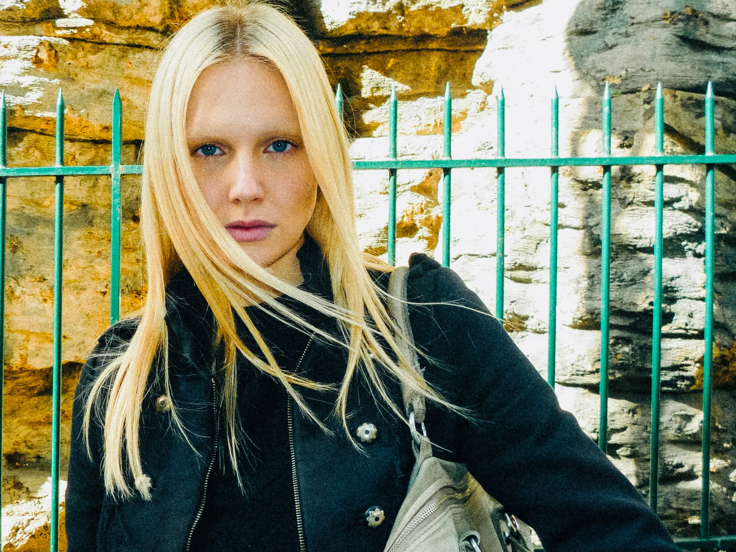 Lea Pliger in front of a green railing and stone