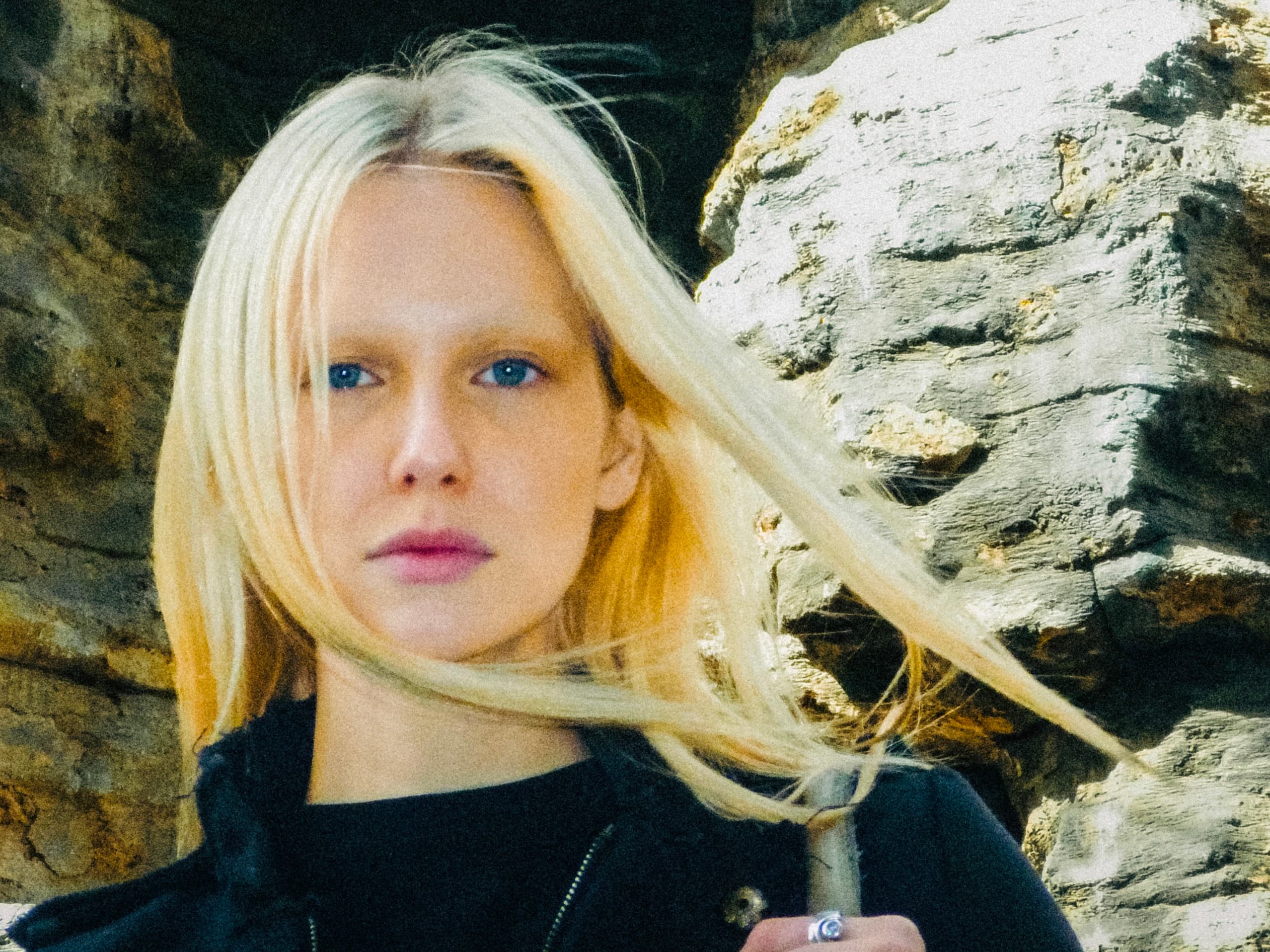 Lea Pliger against rock, her hair in the wind