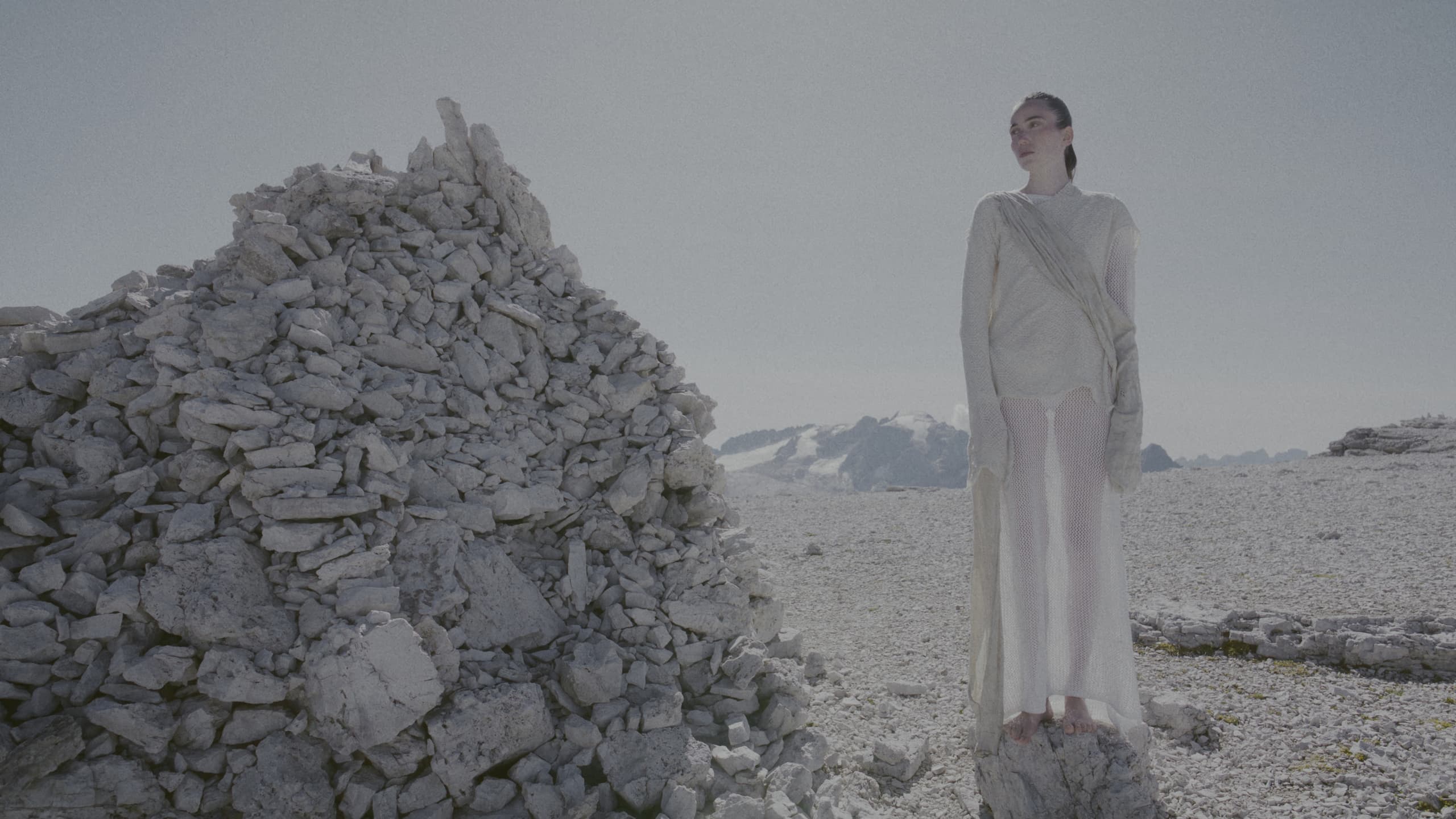 Ellen Larcher beside a stone cairn